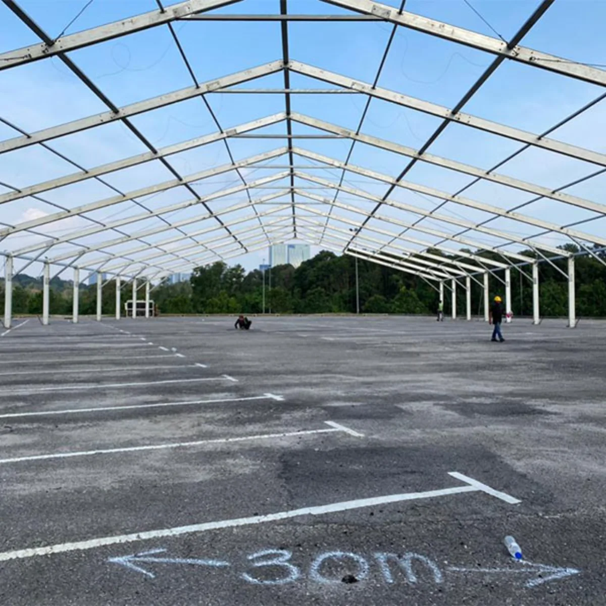 Steel marquee frame being set out on an open paved site