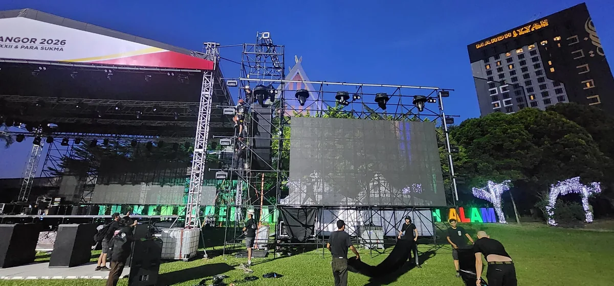 Outdoor stage with LED screen and truss being prepared at dusk