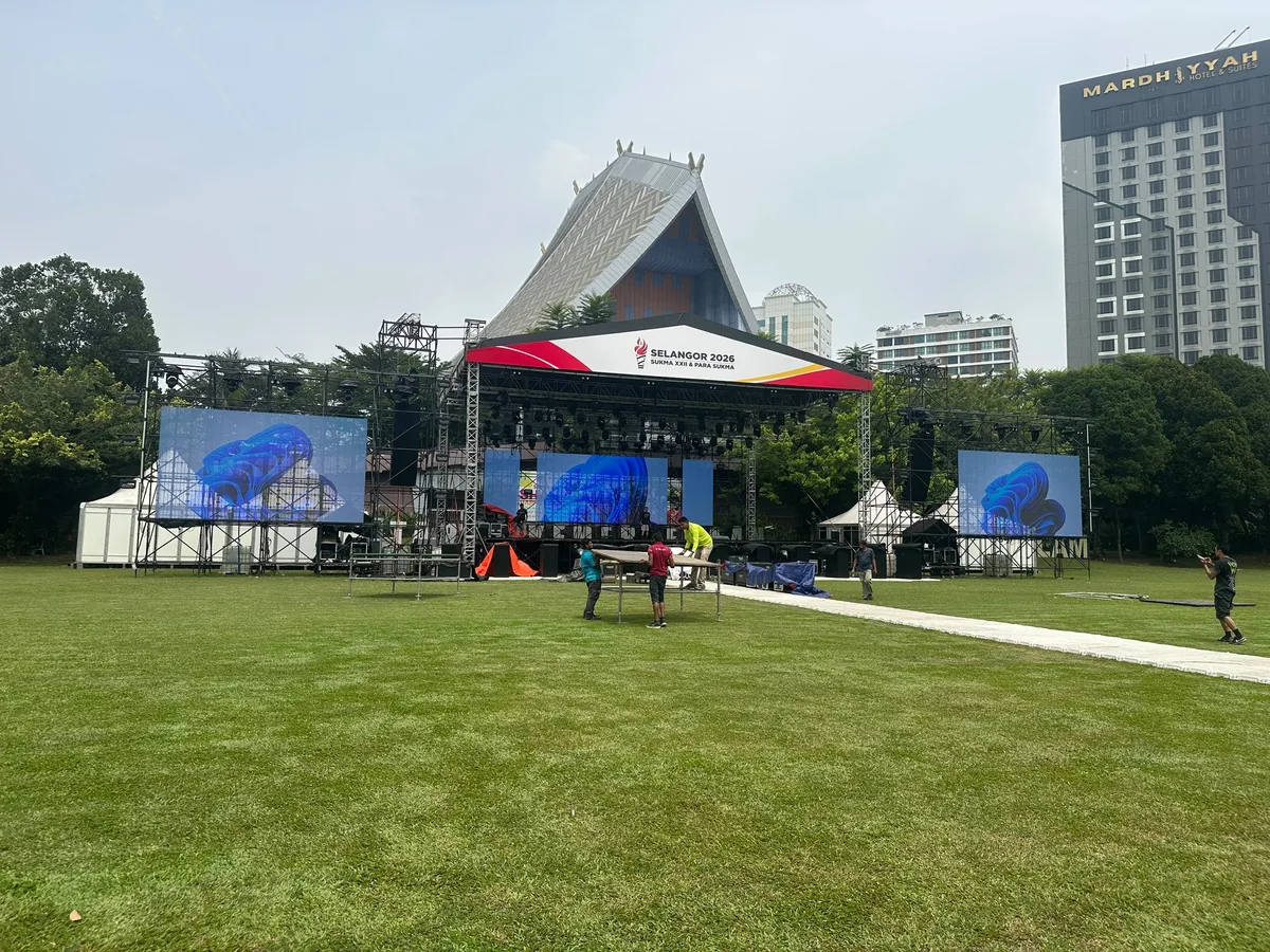 Outdoor stage with roof canopy and two side LED screens on a lawn