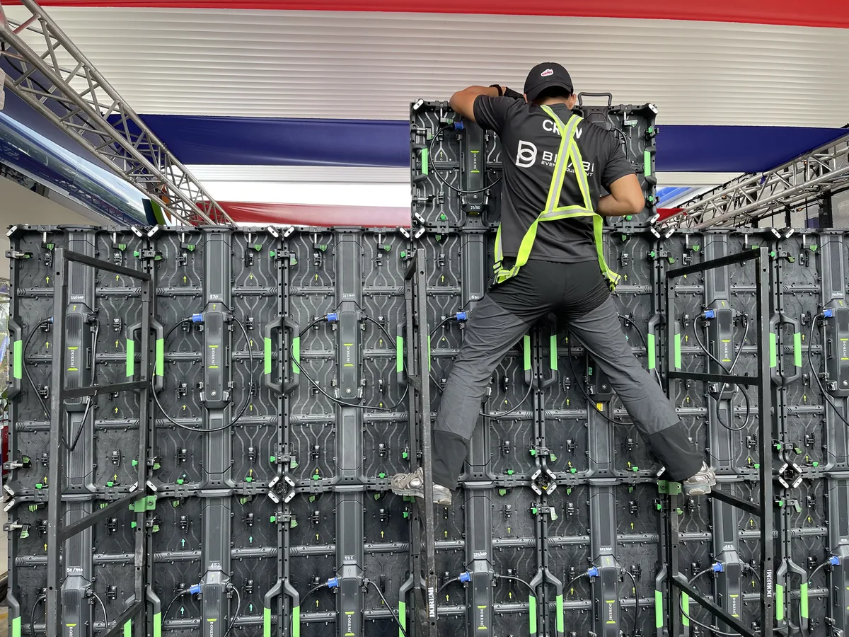 Crew member in a harness fixing LED wall panels