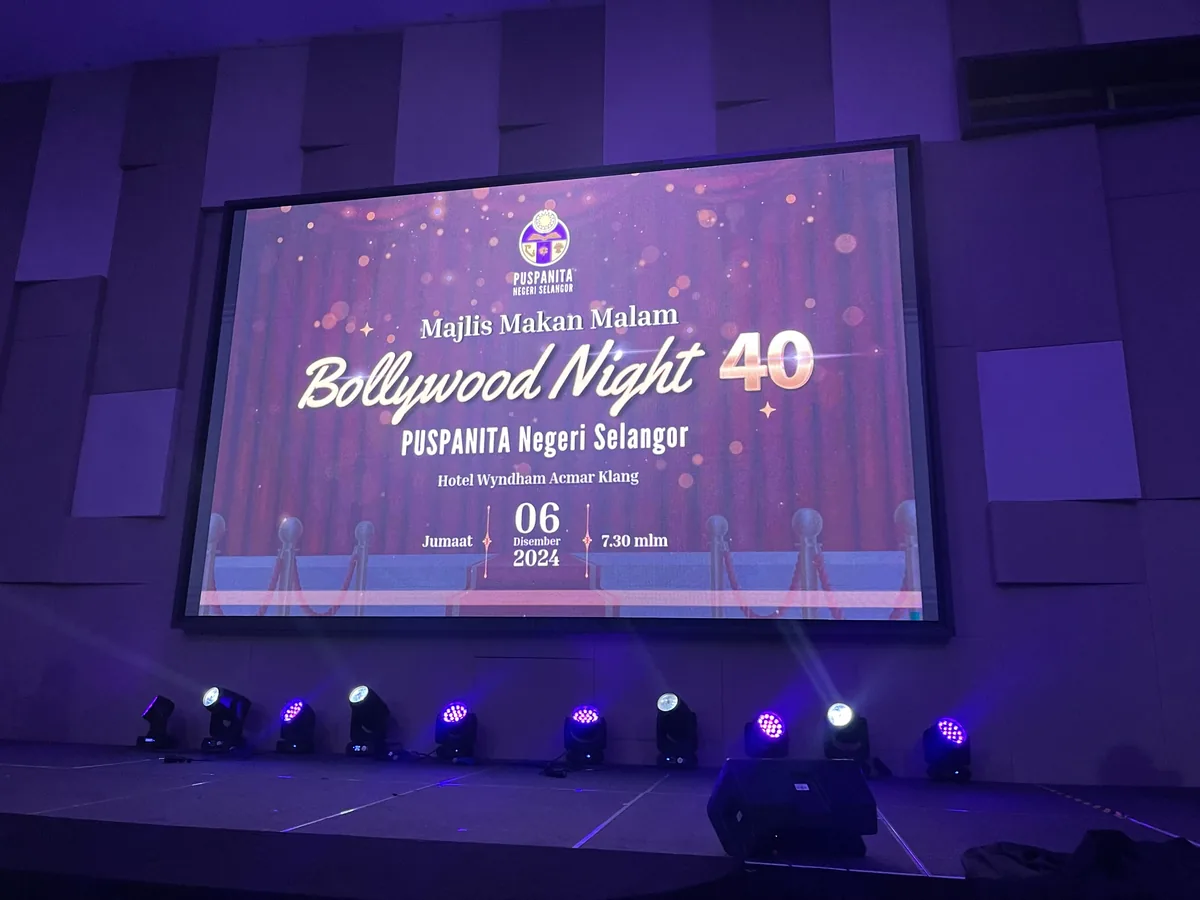 Stage screen showing an event title above a row of stage lights