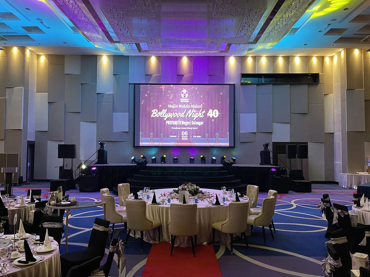 Ballroom with round dining tables facing a stage screen