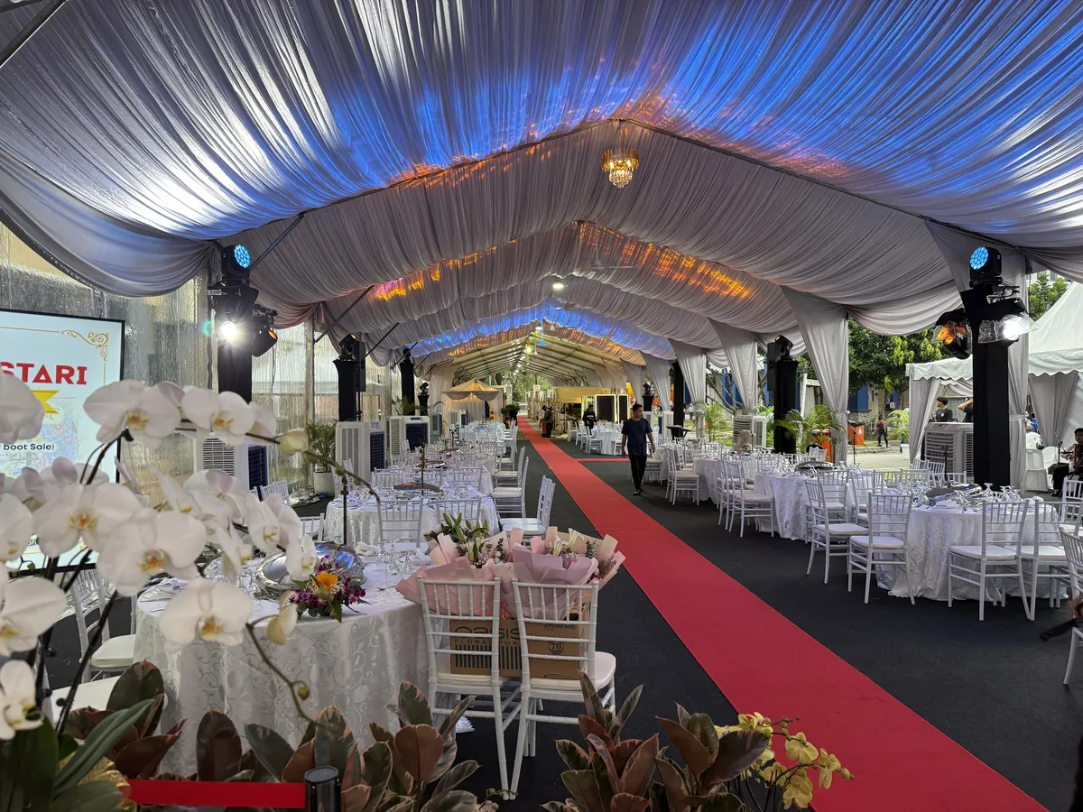 Marquee with blue-lit draping, red carpet and orchid arrangements