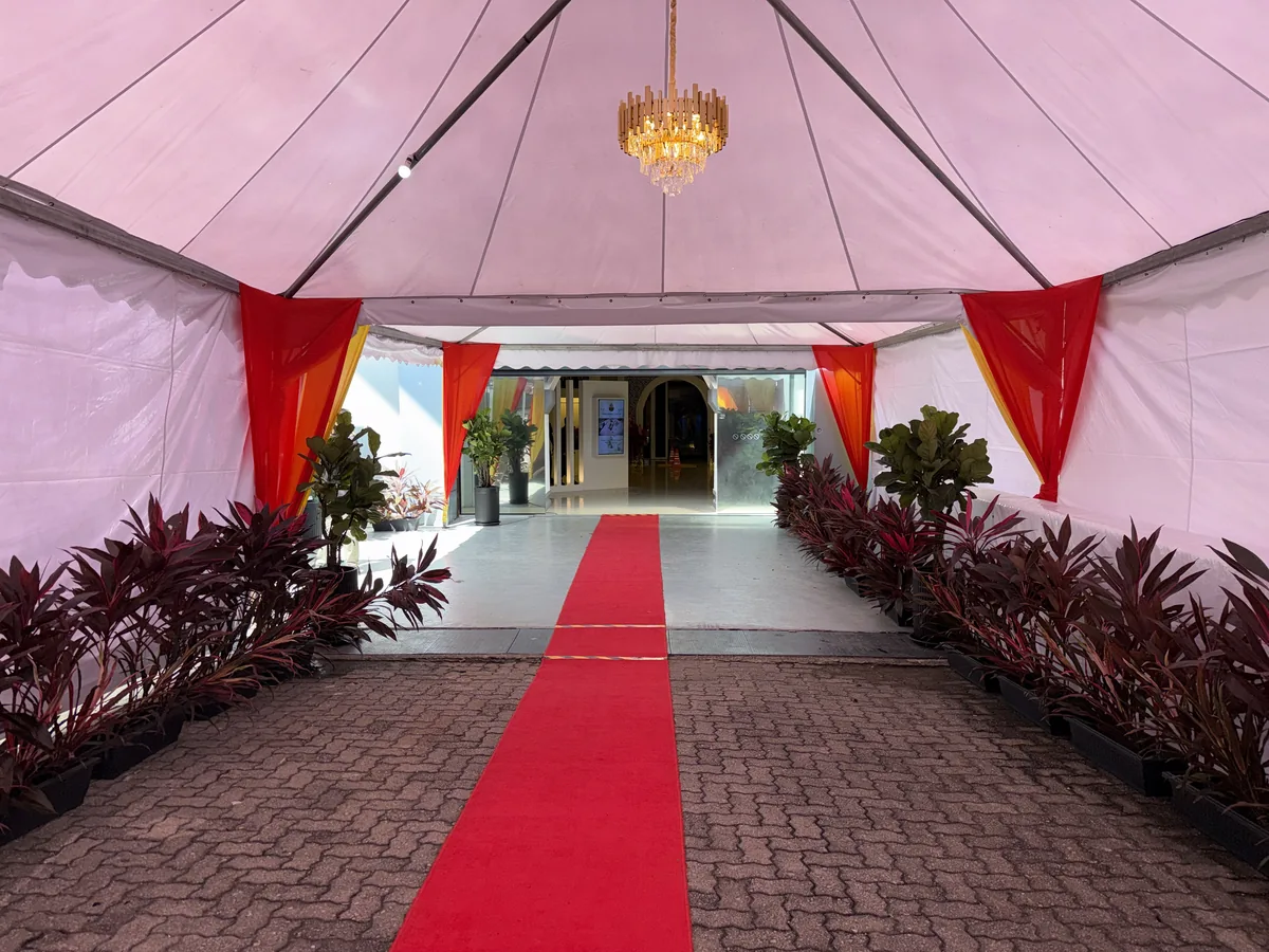 Pink marquee entrance with a chandelier and red carpet